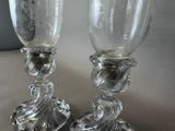 two glass goblets sitting next to each other on a table