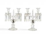 une paire de candélabres en cristal transparent sur socles, sur fond blanc