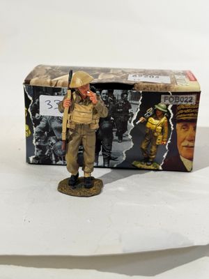 figurine représentant un soldat armé d'un fusil devant une boîte