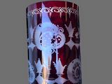 a red vase with white designs on it on a gray surface