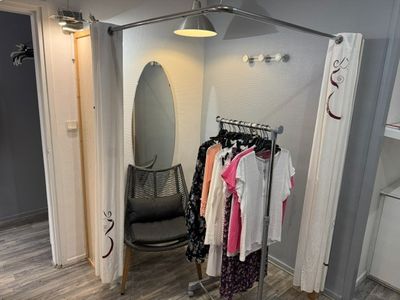 une photo d'un placard contenant des vêtements et une chaise