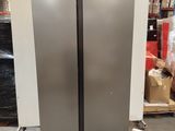 two stainless steel refrigerators sitting on pallets in a warehouse