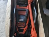un souffleur à fil orange et noir posé dans une boîte en carton