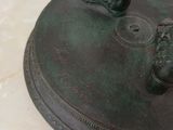 a bronze statue of a woman holding a bird on a pedestal