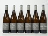 six bouteilles de vin sont alignées sur une table