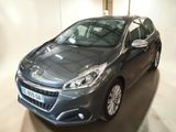 La voiture grise est garée dans le garage, la porte ouverte.