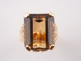 un gros plan d'une bague sertie d'une grosse pierre verte