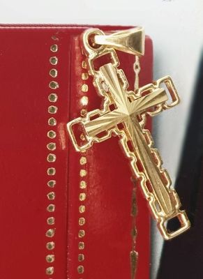 a gold cross on top of a red book