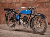 a blue motorcycle that is parked in front of a brick wall
