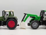 two toy tractors that are sitting next to each other