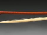 un gros plan d'un archet de violon avec un manche en bois