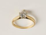 un gros plan sur une bague de fiançailles en or sertie d'un diamant