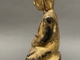 statue of a person sitting on a wooden block with a gray background