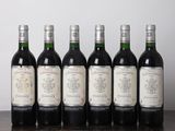 six bouteilles de vin sont alignées sur une table en bois