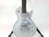 a silver electric guitar sitting on a stand on a white background