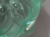 a green glass object that is sitting on a table