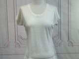 a white shirt on a mannequin stand in front of a wall