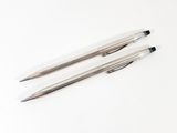 two pens sitting next to each other on a white surface