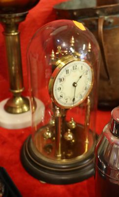 a glass dome with a clock inside of it on a table
