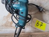 a corded drill sitting on top of a piece of wood