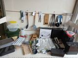 many kitchen utensils hanging on the wall above the counter