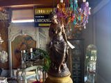 a statue of a woman sitting on a pedestal in a room