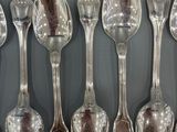 many spoons and spoon spoons lined up on the wall