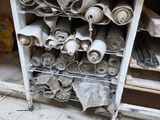 de nombreux rouleaux de tissu posés sur une étagère dans une pièce