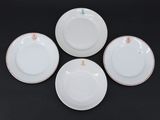 quatre assiettes blanches ornées de bordures dorées et de motifs floraux