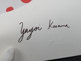 a person holding a piece of paper with a signature on it