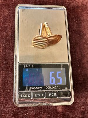 a small scale with a gold ring on top of it