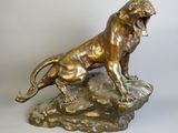 bronze statue of a lion on a rock on a white background
