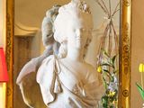 un vase de fleurs et une statue posée sur une commode