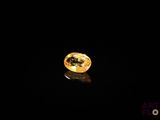 a close up of a yellow diamond on a black surface