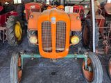 a tractor that is sitting in a garage with other tractors