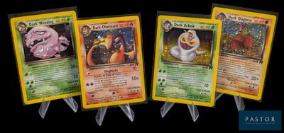 Quatre cartes Pokémon sont alignées les unes à côté des autres sur un fond noir.