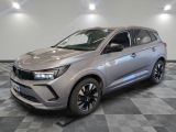 Une voiture argentée est garée dans une pièce au sol en damier.
