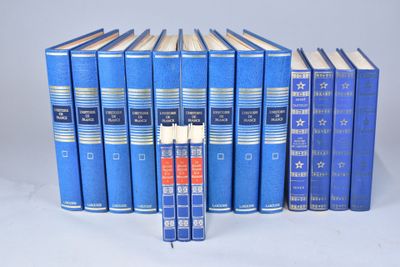 six livres bleus sont alignés sur une surface blanche