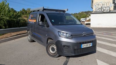une camionnette Citroën garée sur le bord de la route, devant un immeuble