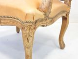 a chair that is made of wood and has a tan leather upholstered seat