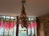 des fleurs suspendues au plafond dans un restaurant, près d'une fenêtre