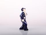 a figurine of a woman standing on a white surface