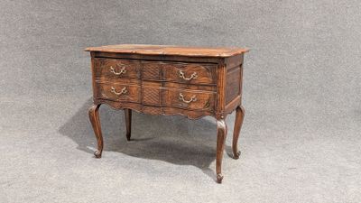 a small wooden chest of drawers on a table