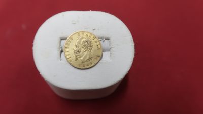 une image représentant une pièce d'or posée sur une boîte blanche