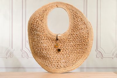 the large woven bag is sitting on a table in front of a wall