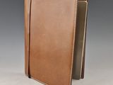 a brown leather journal with a white stitching on the cover