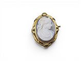 une broche en camée, dorée et blanche, représentant une femme de profil