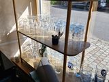 many glasses on the shelves in the corner of the room