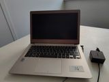 un ordinateur portable posé sur une table avec un chargeur