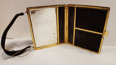 un écrin noir et doré avec un miroir à l'intérieur